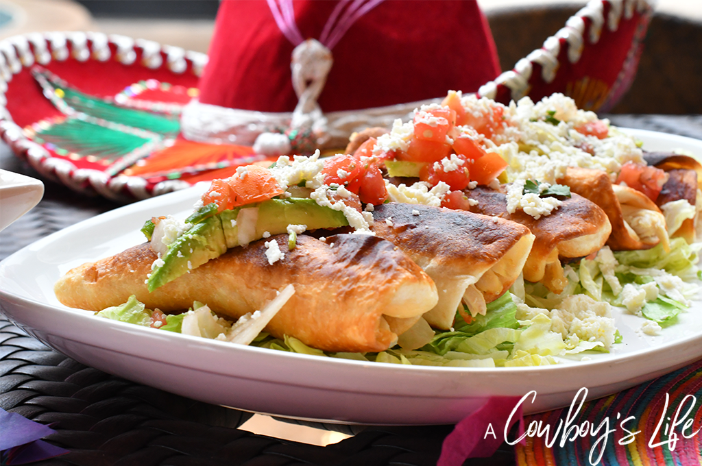 Fried chicken flautas on table with sombrero