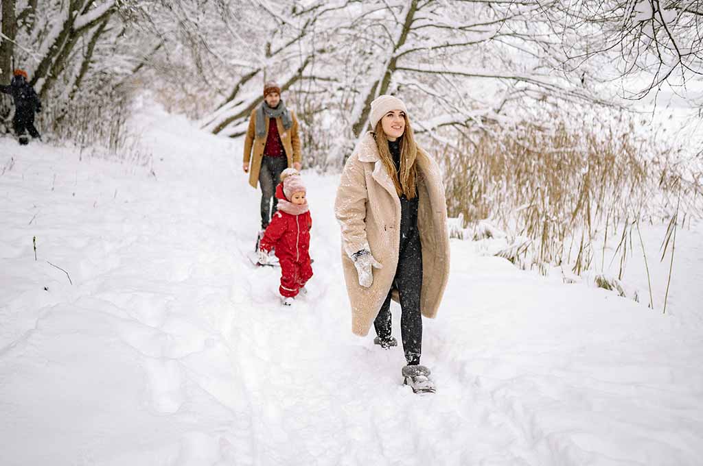 family walking in the snow